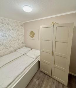 a small bedroom with a bed and a closet at Terrassenhaus, FeWo 45 in Duhnen