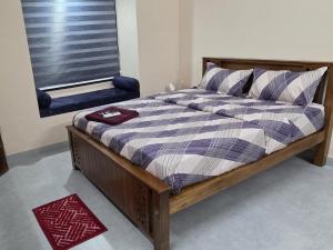 a bed with a wooden frame in a room with a window at Crystal Homestay in Trivandrum