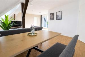 a dining room and living room with a wooden table and chairs at Larooms Merseburg - Apartment NP62 - ServiceApartment für Geschäftsreisende in Merseburg