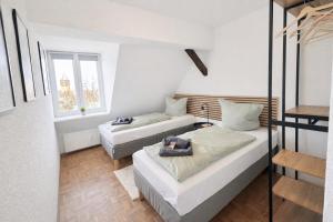 two beds in a room with two windows at Larooms Merseburg - Apartment NP62 - ServiceApartment für Geschäftsreisende in Merseburg