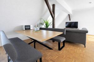 a dining room with a table and a couch at Larooms Merseburg - Apartment NP62 - ServiceApartment für Geschäftsreisende in Merseburg