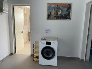 a washing machine in a room with a painting on the wall at Albi12 in Durrës