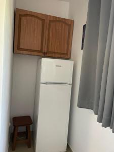 a white refrigerator in a kitchen with wooden cabinets at Albi12 in Durrës