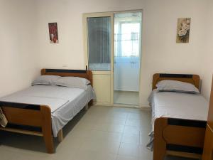 two beds in a room with a window at Albi12 in Durrës