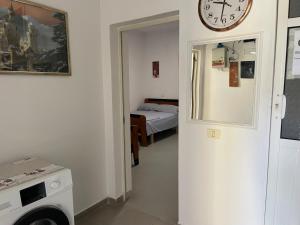 a room with a bed and a clock on the wall at Albi12 in Durrës +2 photos