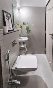 a bathroom with a toilet and a sink at Elegant 1 RK Studio Balewadi in Pune +4 photos