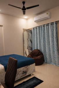 a bedroom with a bed and a ceiling fan at Elegant 1 RK Studio Balewadi in Pune