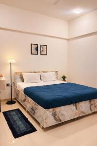 a bedroom with a large bed with blue sheets at Elegant 1 RK Studio Balewadi in Pune