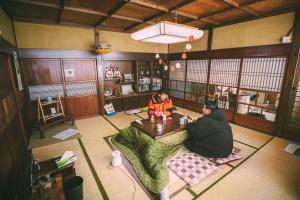 two people sitting at a table in a room at 山形イチマルニマル in Miyajuku
