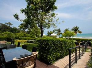 a patio with a table and chairs and the ocean at Escape Condominium By A property in Mae Pim
