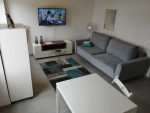 a living room with a couch and a tv on the wall at Studio Świętojańska in Gdynia