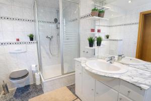 a bathroom with a sink and a shower and a toilet at Larooms Merseburg - Apartment LP01 - 2 Zimmer, 2 Einzelbetten, 1 Doppelbett, große Couch, Küche, Balkon, Waschmaschine in Merseburg +6 photos