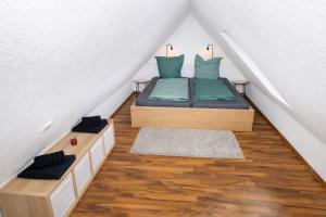a small bedroom with a bed in a attic at Larooms Merseburg - Apartment LP01 - 2 Zimmer, 2 Einzelbetten, 1 Doppelbett, große Couch, Küche, Balkon, Waschmaschine in Merseburg