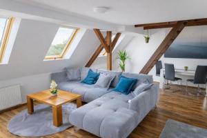 a living room with a gray couch and blue pillows at Larooms Merseburg - Apartment LP01 - 2 Zimmer, 2 Einzelbetten, 1 Doppelbett, große Couch, Küche, Balkon, Waschmaschine in Merseburg