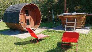 two chairs and a tub next to a wooden cabin at Hospedaje Campestre Ranco Naturaleza - Desayuno incluido in Lago Ranco