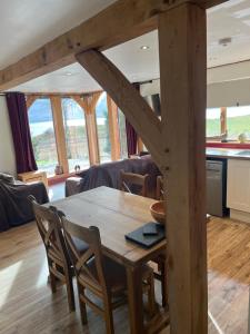a wooden table and chairs in a living room at Tigh a Chabar in Lochaline