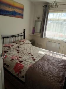 a bedroom with a bed with a comforter on it at 477 California Sands Chalets in Scratby