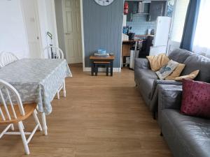 a living room with a table and a couch at 477 California Sands Chalets in Scratby