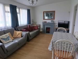 a living room with a couch and a table at 477 California Sands Chalets in Scratby
