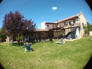 a person sitting in a lawn chair in front of a house at Albergue San Bruno in Moratinos