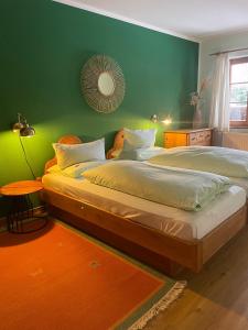 a bedroom with two beds and a green wall at Landhaus Susewind in Ahrenshoop +23 photos