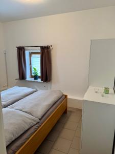 a bedroom with two beds and a window at FeWo Gretl Stauden in Walkertshofen +4 photos