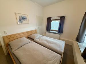 a small bed in a room with a window at FeWo Gretl Stauden in Walkertshofen