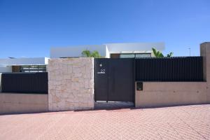 a building with a black door and a brick wall at L'au D'evi in Rojales