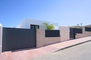 a fence on the side of a street with a sidewalk at L'au D'evi in Rojales