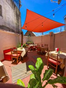 a patio with tables and chairs and a red umbrella at Jiro Hôtel in Antananarivo