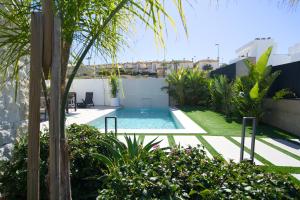 a backyard with a swimming pool and plants at L'au D'evi in Rojales +22 photos