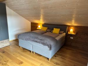 a bedroom with a bed with yellow pillows on it at Fritz Alpchalets - Haus Lechtal in Vorderhornbach