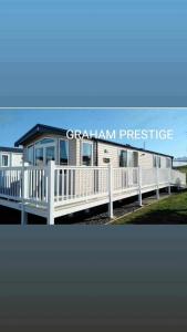 a modular home with a porch and a white fence at Grahams Prestige Craig Tara in Minishant