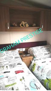 a bedroom with two beds and a sign on the wall at Grahams Prestige Craig Tara in Minishant +3 photos