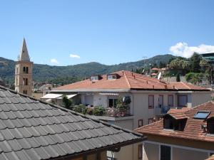 uma vista sobre os telhados dos edifícios e uma igreja em Otto - Bilocale ad Alassio em Alassio