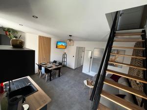 a living room with a staircase and a dining room at L Orée des Thermes in Saint-Amand-les-Eaux