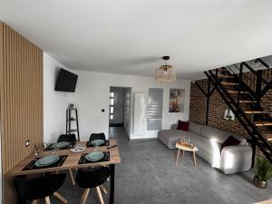 a living room with a couch and a table at L Orée des Thermes in Saint-Amand-les-Eaux