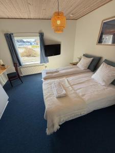 a bedroom with a large bed and a window at VØ Budget Drop Inn in Thisted