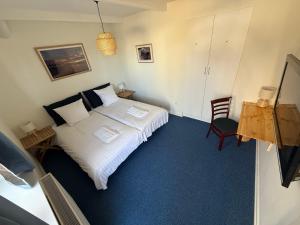 a small bedroom with a bed and a chair at VØ Budget Drop Inn in Thisted +7 photos