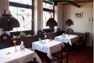 zwei Tische in einem Restaurant mit weißen Tischdecken in der Unterkunft BoardingHouse N22 Oberboihingen in Oberboihingen