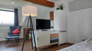 a bedroom with a desk with a tv and a chair at Ferienwohnung Kohl'sche Hof in Juhöhe