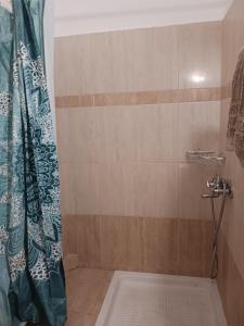 a bathroom with a shower with a shower curtain at Anastasios Room's in Olympic Beach
