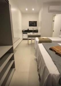 a hotel room with two beds and a desk at Condomínio Vila Eco Barra apto 215 in Barra Grande +5 photos