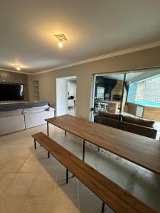 a living room with a wooden table and a couch at Cobertura Premium com Piscina Exclusiva in Guarujá