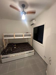a bedroom with a bunk bed and a ceiling fan at Cobertura Premium com Piscina Exclusiva in Guarujá