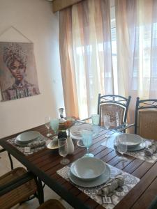 a wooden table with plates and wine glasses on it at Anastasios Room's in Olympic Beach