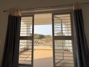 a sliding glass door with a view of a balcony at Harmony Palace Guest House in Nashik