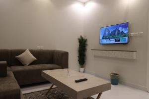 a living room with a couch and a tv on a wall at City residence in Medina