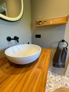 a bathroom with a large white bowl sink on a wooden floor at de Relliner Hüs in Heringsdorf