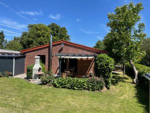 a brick house with a porch in a yard at de Relliner Hüs in Heringsdorf